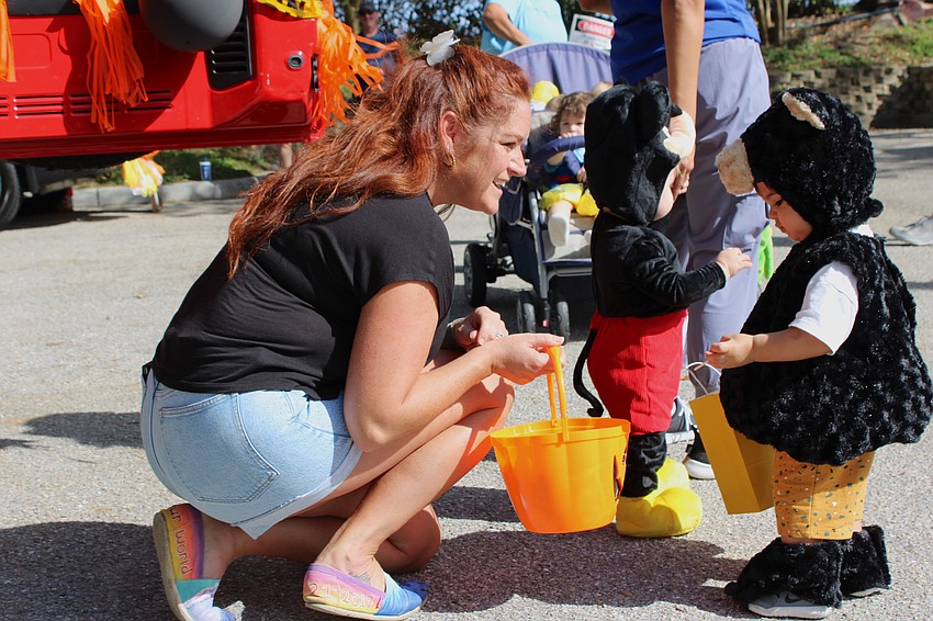 Jaclyn McCarthy makes sure Tito Toniolo Teixeira gets just the right candy during the Kiddie Academy Halloween parade.
