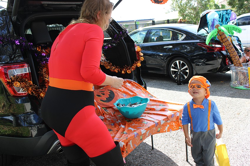 Jessica McCord, the mom of two Kiddie Academy students, hands out candy to student Ethan Rosales.