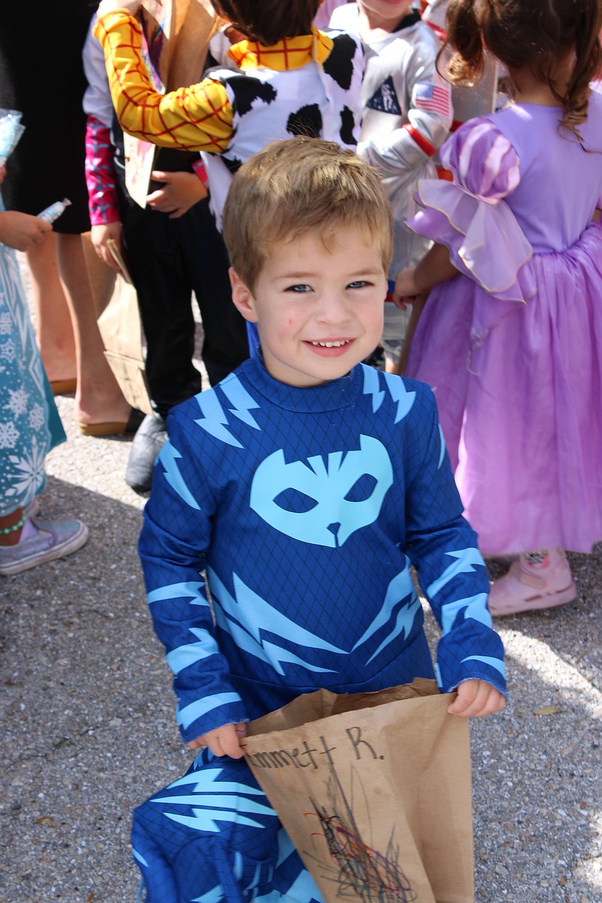 Kiddie Academy student John Gosnell is happy to fill up his bag during the school's Halloween parade.