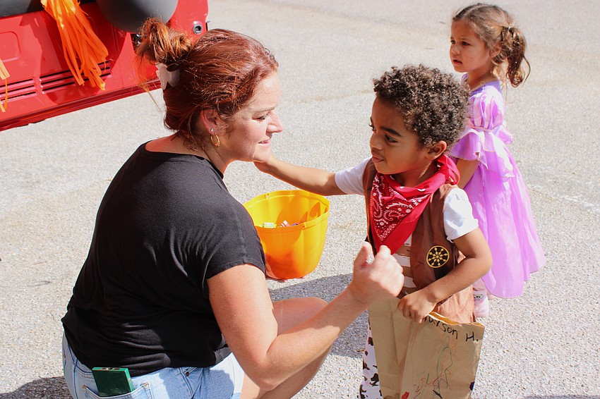 Mom Jaclyn McCarthy gets a hug from her son, Marcus McCarthy, during the Kiddie Academy parade. Student Jade Ramirez is in the background.