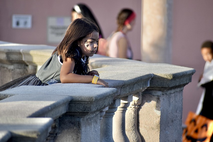 Hazel Suarez, 6, looks out at the activity in the courtyard.