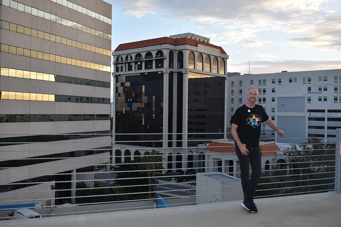 Sarasota Rising founder Jeffery Kin poses on a parking lot downtown with the post-Milton skyline of Sarasota in the background.