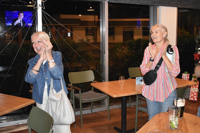 Barbara Campol and Leslie Butterfield applaud the victory of Kathy Kelley Ohlrich.