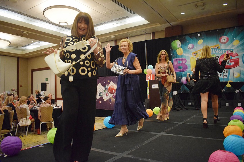 Women walk the runway to model the bags available to win.