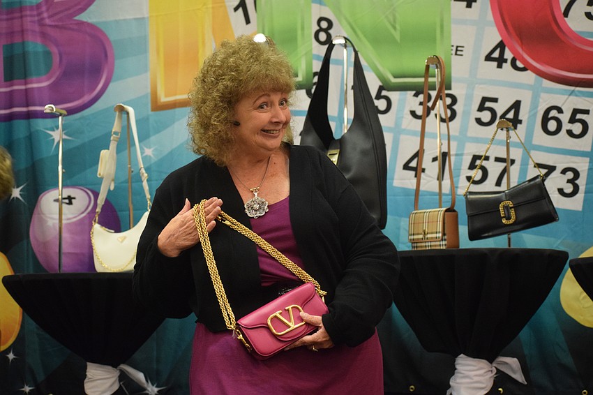 Parrish's Diane Fogo-Harter shows off the Valentino Loco Rose purse she won. 
