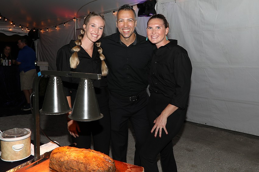 Sharky's servers and carvers Kaley Houston, Alex Surdu, and Lilly Bakulski prepare to fill plates.