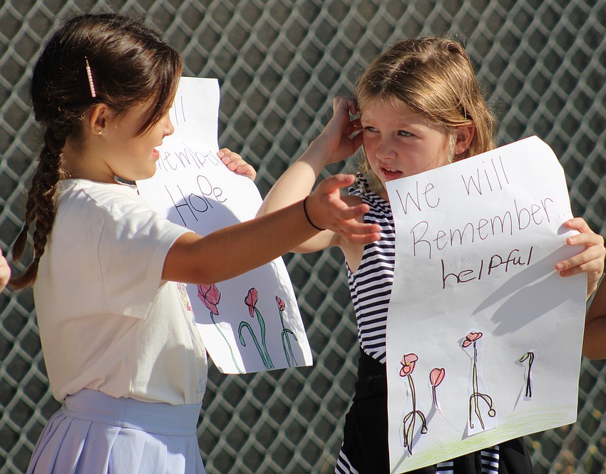 McNeal second graders Maria Frias and Olivia Shipp are ready to hoist their signs for the veterans.