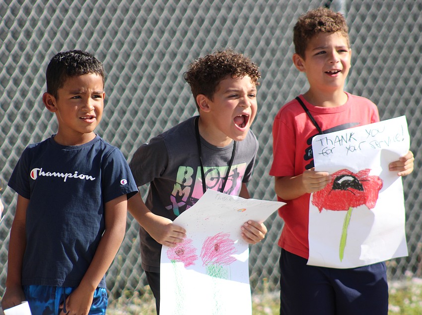McNeal second graders Gabriel Miranda, Isaiah Lopez, and Henry Zaehler make some noise for the veterans.