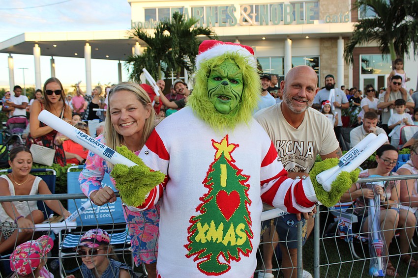 Venice's Christine and Robert Stesney prove that it's not just kids who love a parade as they visit with the Grinch.