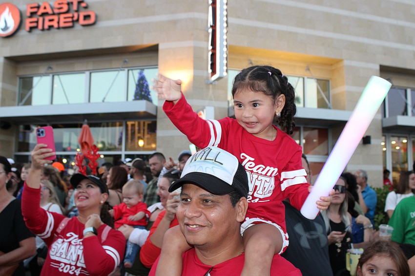 Lakewood Ranch 3-year-old Adrianna Rivas is having a great time at the Santa's Grand Arrival Parade on the shoulders of her dad William Rivas.
