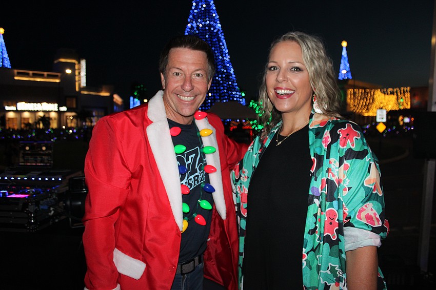 David Jones and Meredith Michaels of 107.9 WSRZ radio enjoy their role as masters of ceremonies at the 2024 Santa's Grand Arrival Parade at the Mall at UTC in Sarasota.
