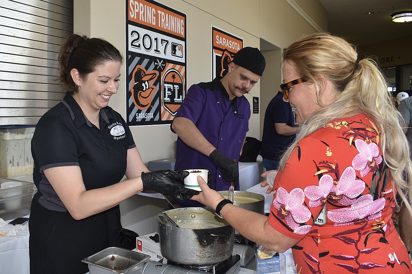 Abigail Bragg and Jesse Mann of Siesta Key Oyster Bar serve soup to Samantha Lemmer.