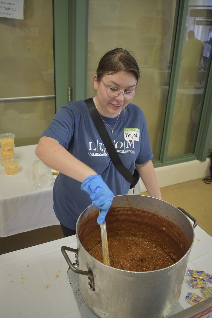Brandy Bay mixes a bowl of chili from Gecko's Grill & Pub.