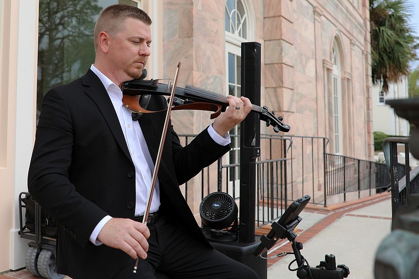 Matt Dendy plays the electric violin during cocktail hour.