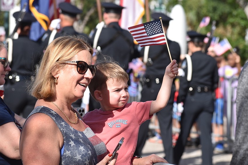Lisa Beaumont and Jamieson Beaumont, 2, welcome the parade vehicles.