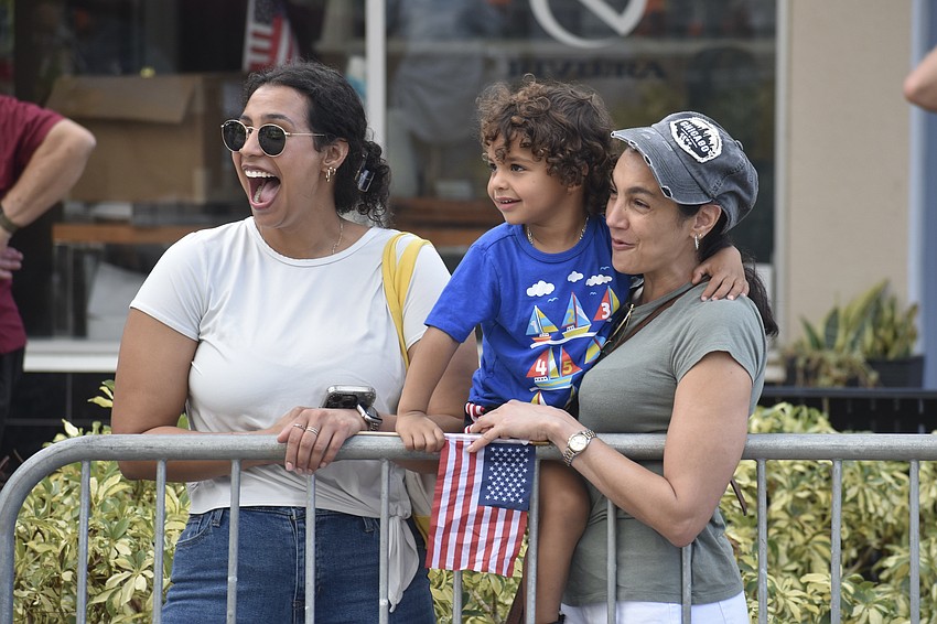 Yuly Torres, Ezra Torres, 3, and Yudi Torres watch the parade.