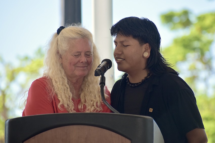 Jan Solomon recites a prayer, while Inehue Nenquimo, an exchange student from Universidad San Francisco de Quito in Ecuador, translates it into Spanish.