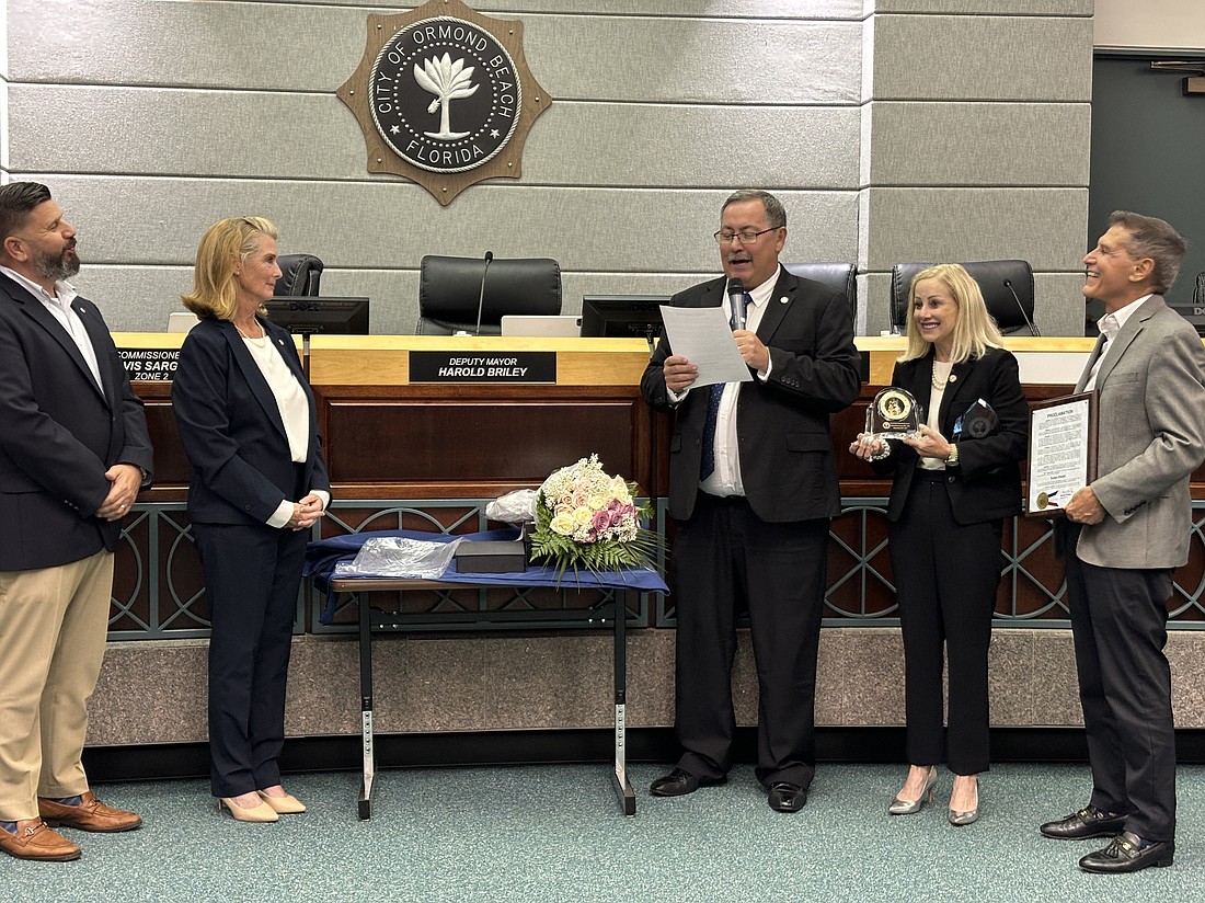 Deputy Mayor Harold Briley (third from left) reads a proclamation for Susan Persis, as her husband Carl (far right) and fellow commissioners Travis Sargent and Lori Tolland watch. Photo by Jarleene Almenas