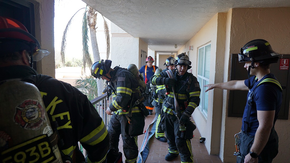 The crew gets ready to move the hose from the working floor up to the floor above, where the simulated "fire" would be.