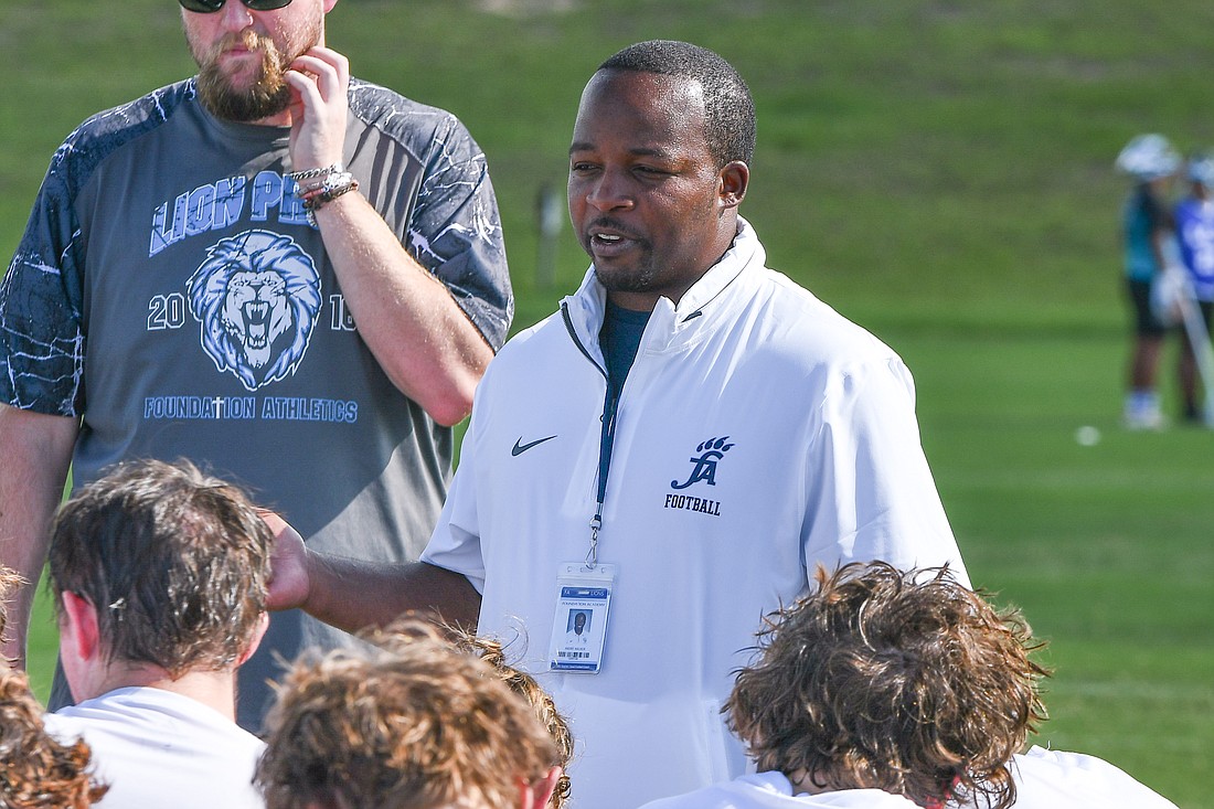 Former Foundation Academy football coach Andre Walker spoke to the team at a practice.