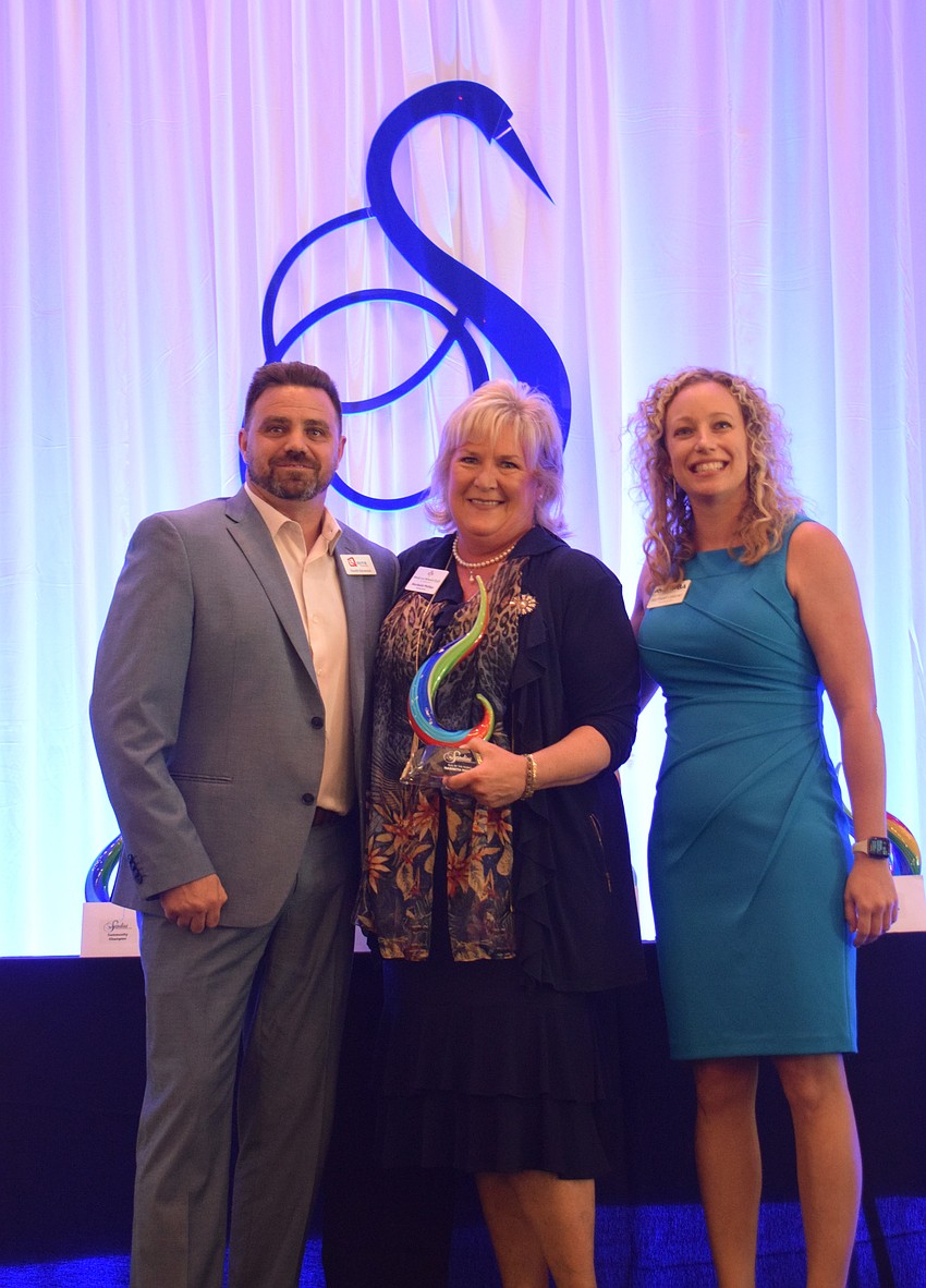 Maribeth Phillips (center) of Meals on Wheels Plus of Manatee accepts the Bull by the Horns award from Gareth Stevenson of Rite Technology and Brittany Lamont, the president and CEO of the Lakewood Ranch Business Alliance.