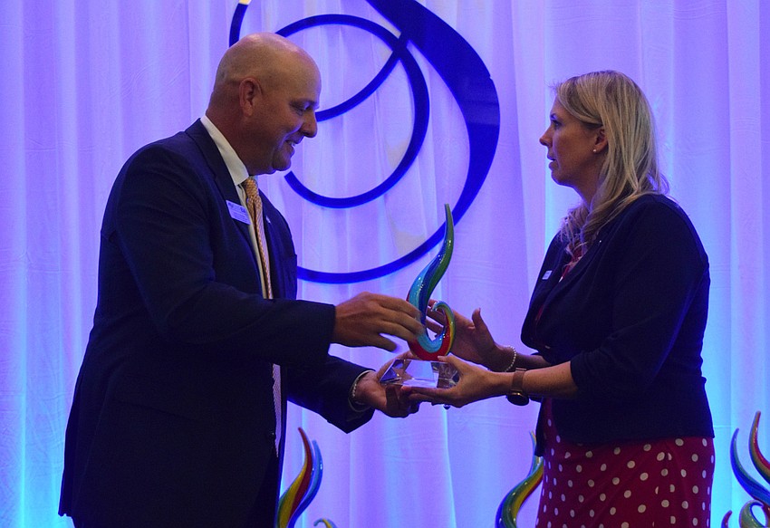 David Otterness of Willis Smith Construction presents the Community Champion award to Bank of America's Jamie Kahns.