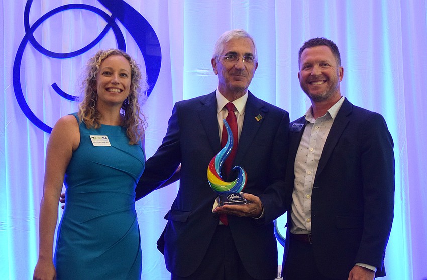Brittany Lamont, the president and CEO of the Lakewood Ranch Business Alliance, and alliance member Wayne Parrish present the Company Community Champion award to Rick Piccolo (center), the president and CEO of the Sarasota-Bradenton International Airport.