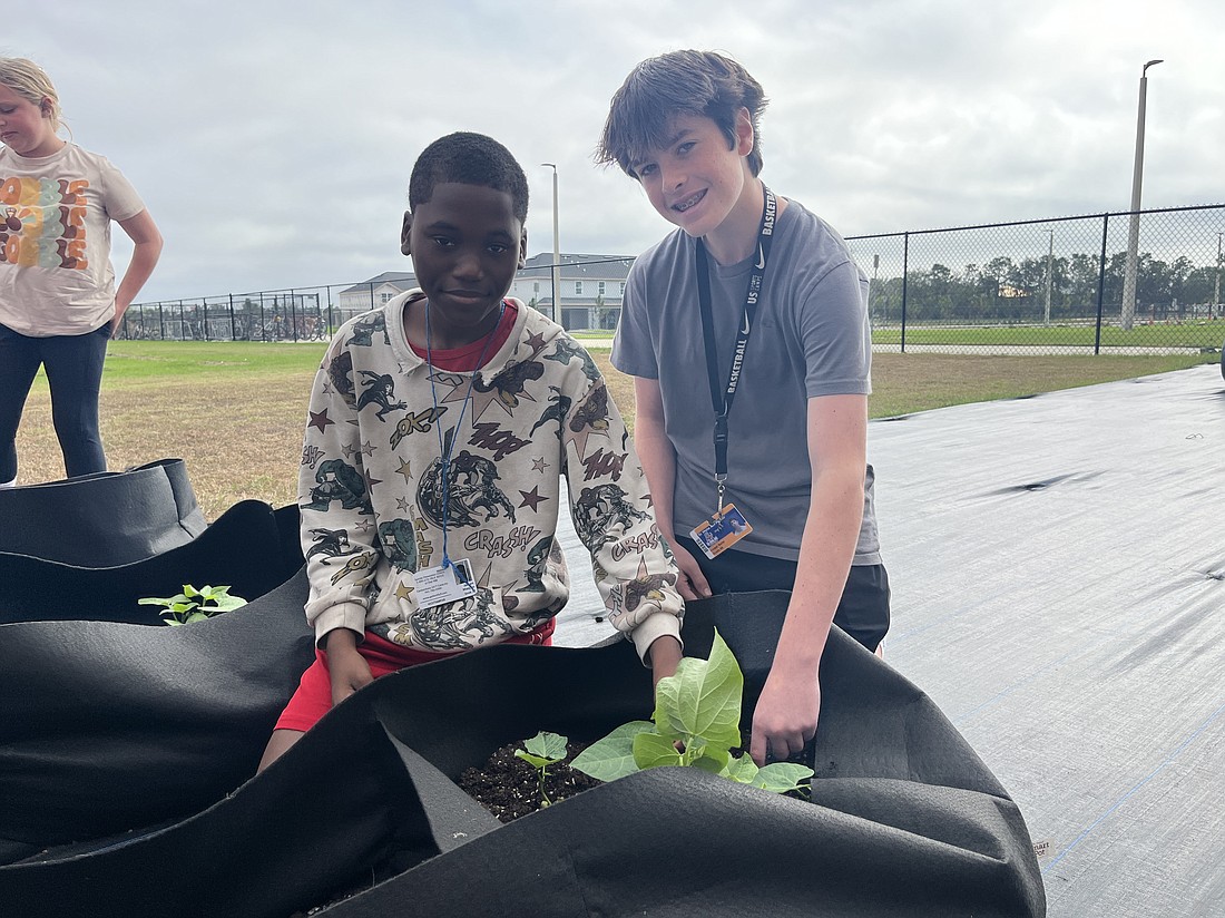 Dr. Mona Jain Middle School's new agriculture program gives seventh grader Jaiden Morgan and eighth grader Cooper Burke an opportunity to work hands on with plants.