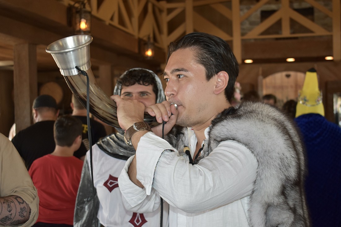 Sarasota's Dino Bever blows into a medieval animal horn.