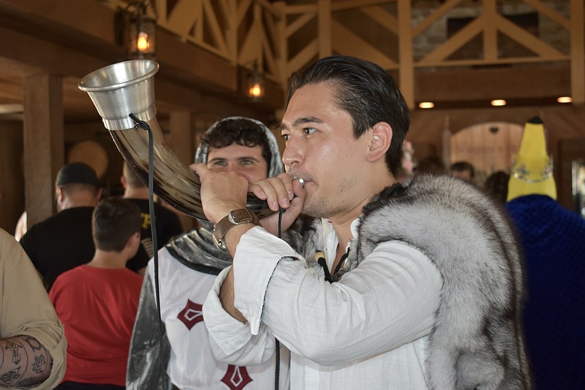 Sarasota's Dino Bever blows into a medieval animal horn.
