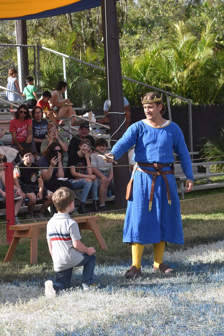 Gainesville's 5-year-old Titan Watson is knighted by King Arthur.