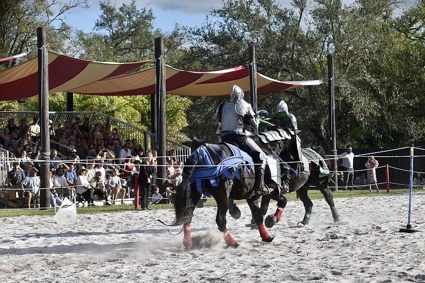The jousters strike their lances at each other's shields during the pass.