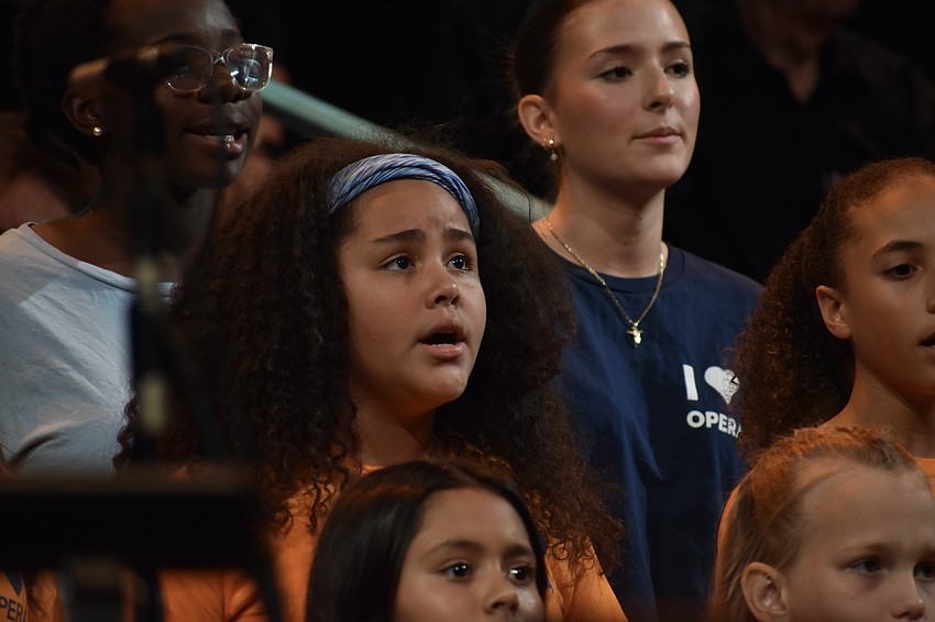 Abril Sanchez, 10 (center) sings a song from 