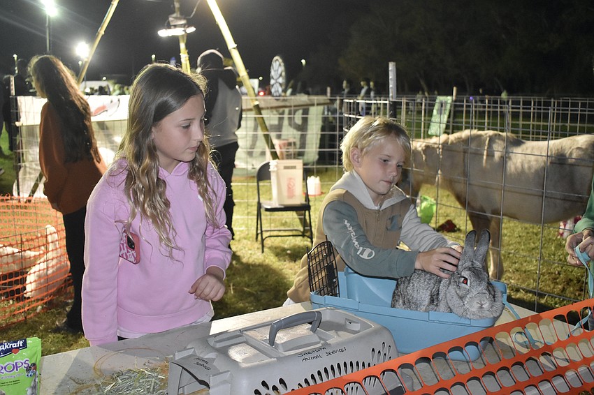 Fourth grader Harlowe Dean and second grader Henton Dean meet Blue the rabbit.