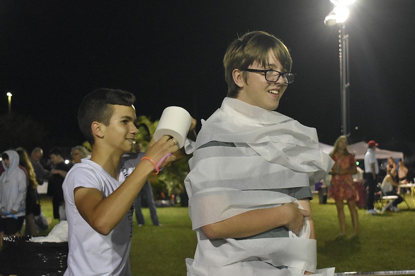 Eighth graders Wilmay Martinez and Dylan Sutterfield try the mummy wrap.