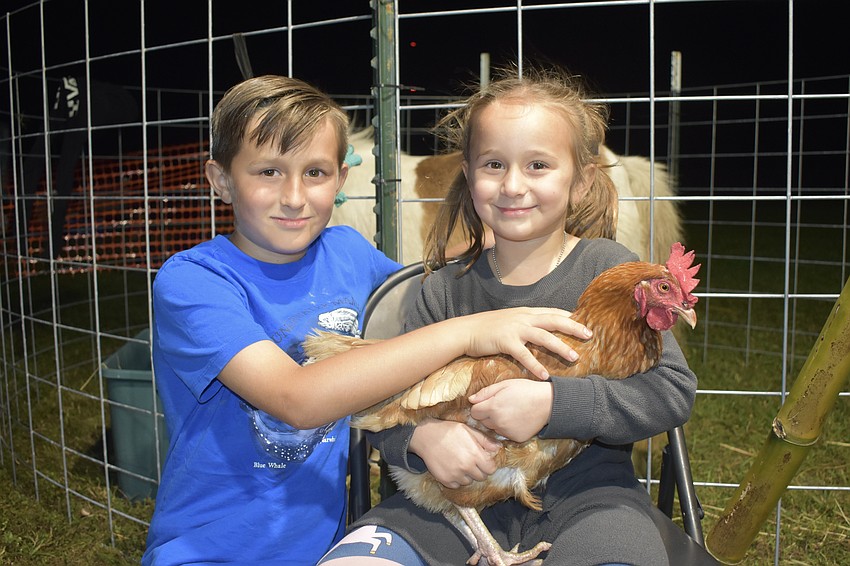 Noble Molineaux, 8, and Nyla Molineaux, 6, hold Brownie the chicken.