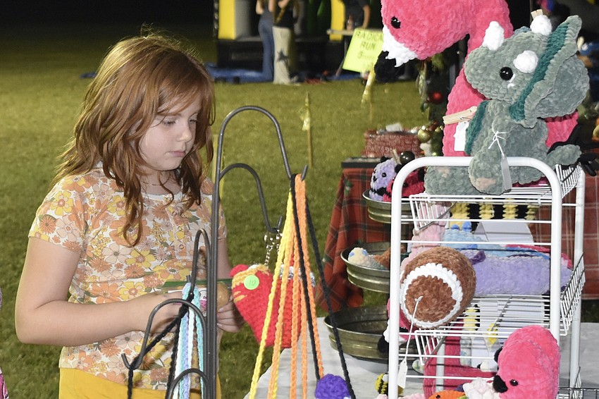 Fifth grader Taylor Johnson looks over the crochet items on display.