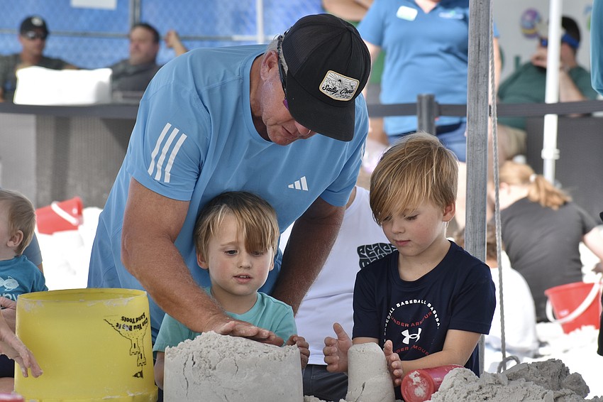 Jim Schlosser, Bradford Henrion, 3 and Baker Henrion, 5 work together to build sandcastles.