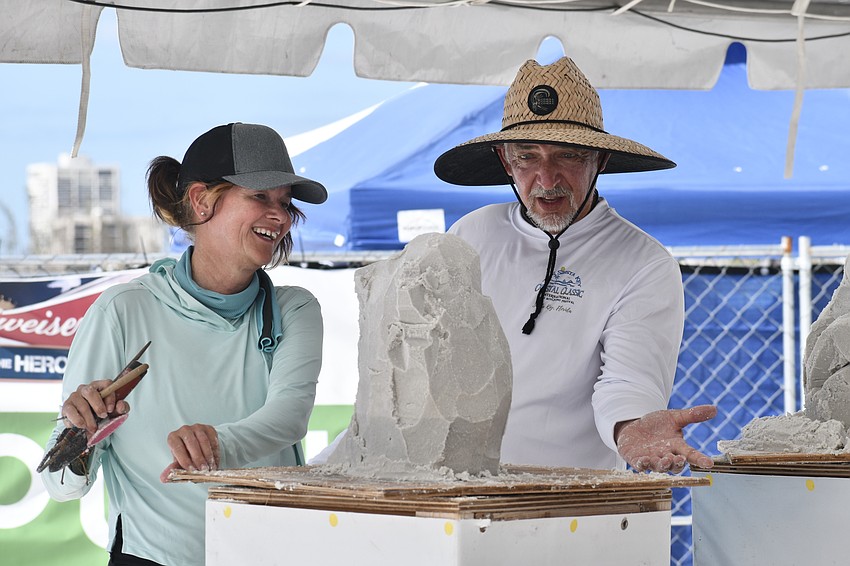 Sculptors Ludo Roders and Brian Wigglesworth, a former Siesta Key resident, spin Roders' lizard sculpture, the winner of the Quick Sand competition.