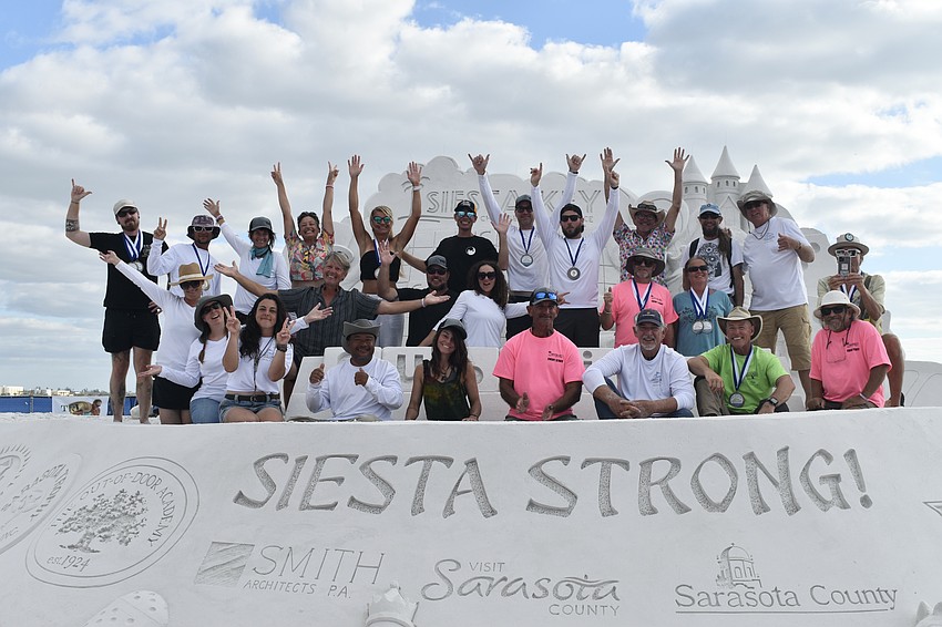 Artists gather atop the centerpiece sculpture.