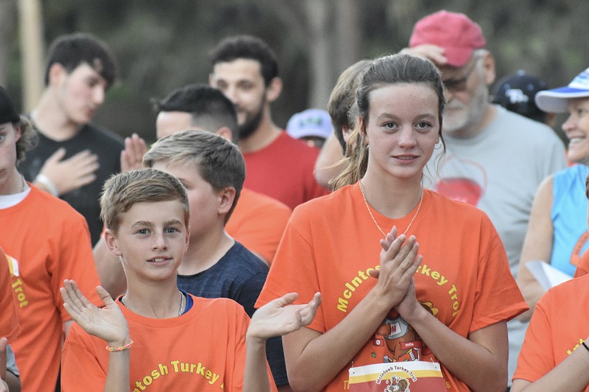 Fifth grader Brody Peters 5th grade and ninth grader Brooklyn Peters applaud as the Turkey Trot is officiated.