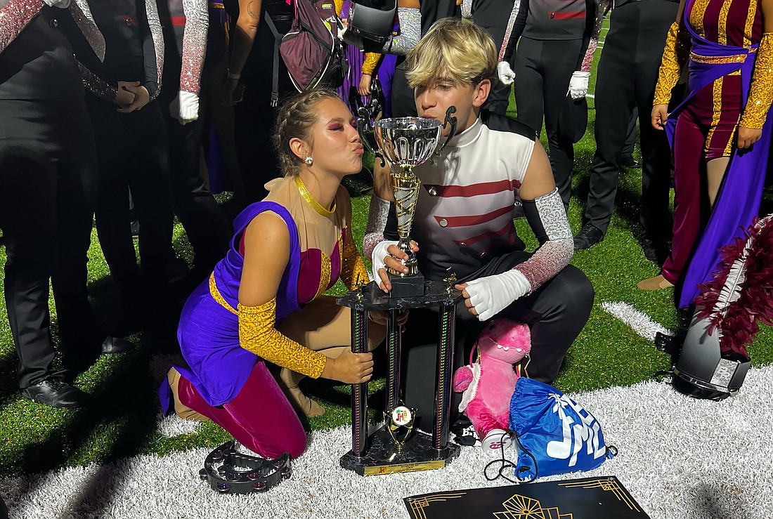 Braden River High School's Kirsten Soler and Quinn McGettigan kiss the trophy. The Marching Band of Pirates earned its first state championship title in five years.