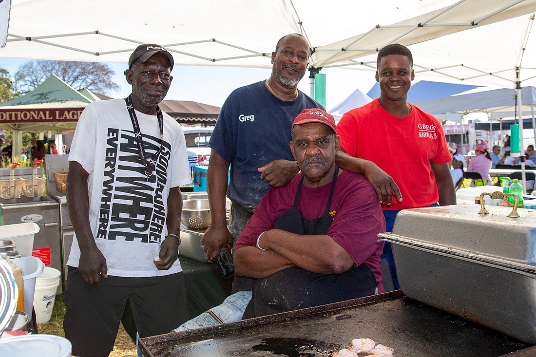Lonnie Burkes (seated), Troy Stanton, Greg Lewis and John Williams have been serving up seafood at Riverfest for the past 10 years. Lewis and Williams also work for the city of Ormond Beach. Photo by Suzanne McCarthy