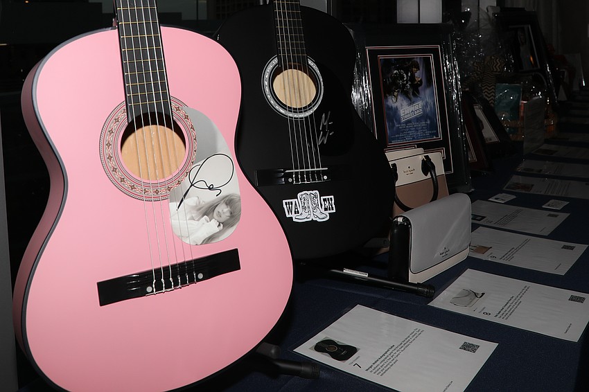 Silent auction items include a pink guitar signed by pop star singer Taylor Swift.
