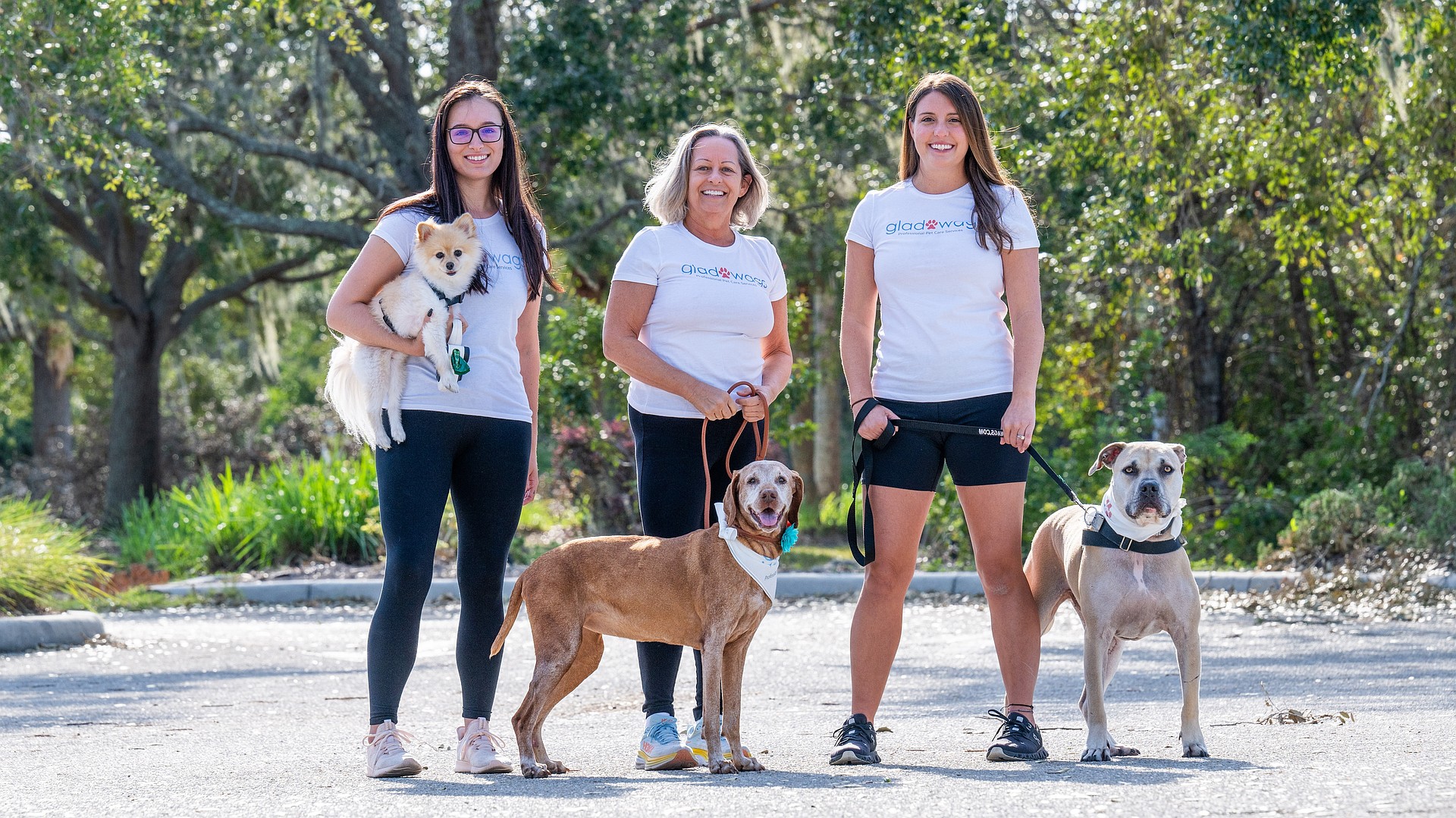 Glad Wags marketing coordinator/field manager Csenge Csicsek with her dog, Uka; Glad Wags founder Chris Cooper with her dog, Ivy; and office/field manager Amanda Gunter with her dog, Bodhi.