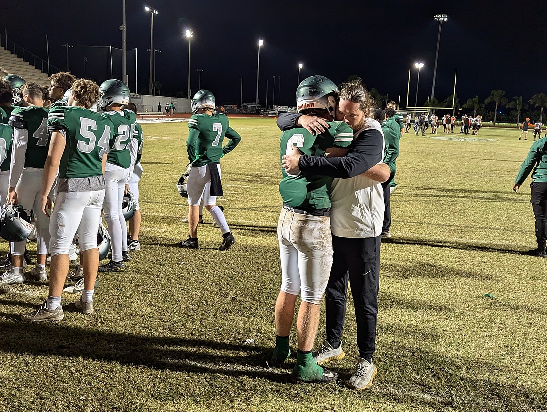 FPC coach Daniel Fish hugs senior Jesse Shirley after the Bulldogs' 36-35 loss to Spruce Creek in the Region 1-7A quarterfinals on Nov. 15. Photo by Brent Woronoff