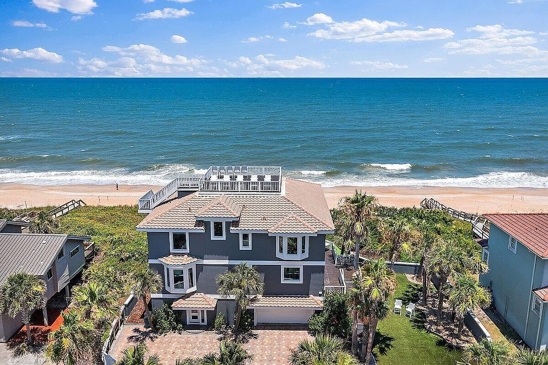 Oceanfront three-story home with Intracoastal Waterway views. Features four bedrooms, three full and one half-bathrooms, porches, balcony, rooftop deck, putting green, four-car garage and dune walkover.