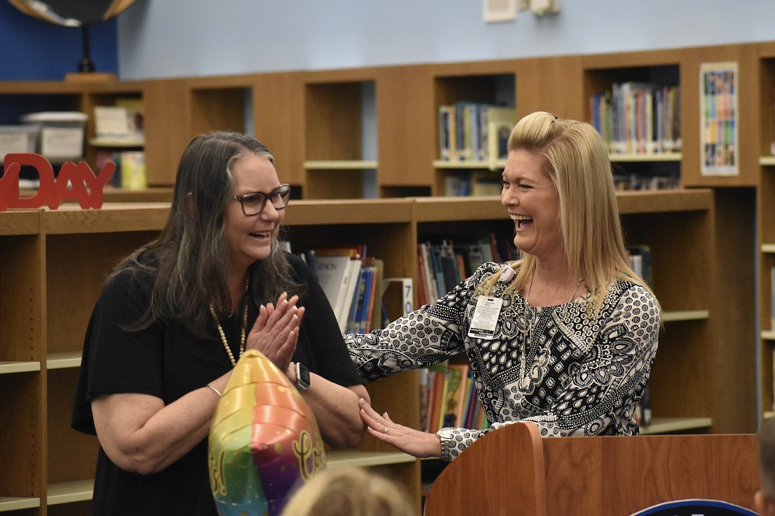 Carman Larson, left, reacts as principal Jennifer Nzeza announces her as the 2024 school counselor of the year.