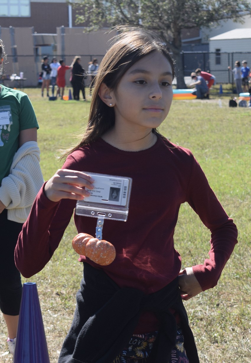 Fifth grader Sofia Velez uses her ID to carry the pumpkin.