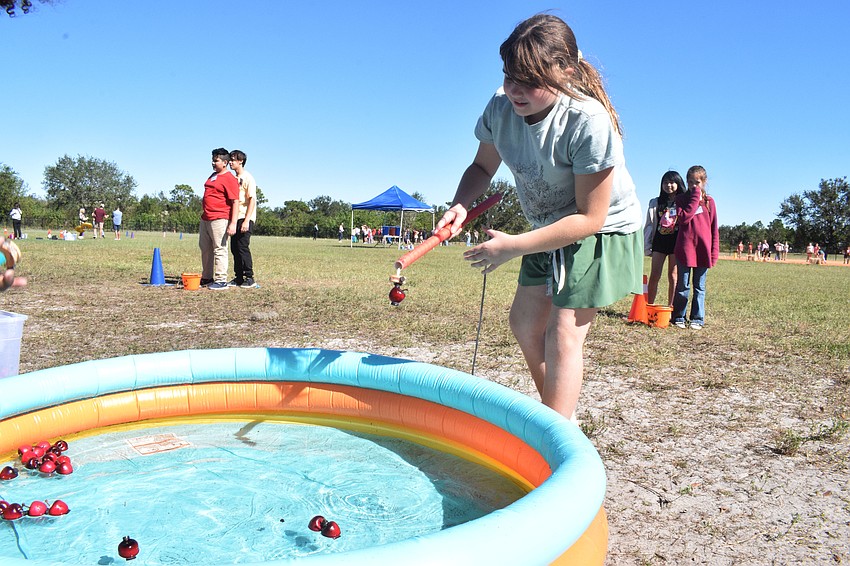 Fifth grader Olivia McGettigan says the key to fishing for apples is pulling the string to get the magnet on the pole straight.
